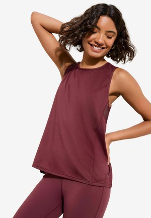 Tamsiai raudona sportinė liemenė su tekstūruota paviršiaus apdaila ir rankovių stiliumi. Derinama su tokios pat spalvos bordo tamprėmis, turinčiomis laisvą fitą.