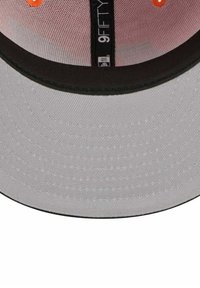 Baseballkappe mit grauem Schirm, schwarzen Akzenten und orangefarbenem Logo. Verfügt über ein strukturiertes Design und Netzmaterial am oberen Teil.