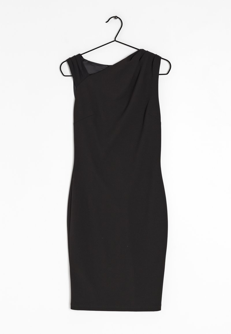 Robe noire sans manches au genou avec un décolleté asymétrique accrochée sur un cintre noir sur fond blanc.