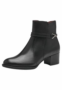 Bottine noire en cuir lisse avec un bout rond, un petit talon bloc, et une sangle décorative avec des détails en métal argenté.