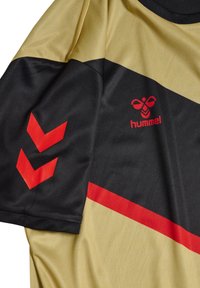 Maglia sportiva nera e oro con motivi geometrici rossi e logo. Realizzata in tessuto morbido, presenta maniche corte e scollo rotondo.