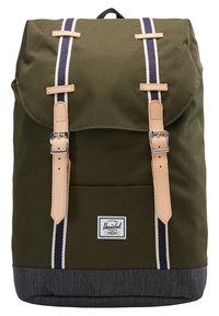 Grøn lærredsrugtaske med læderremme, marineblå og cremefarvede striber og en bund i denim. Har en forlomme og et Herschel logo-patch.