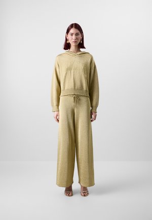 Ensemble de survêtement en maille jaune clair comprenant un hoodie court et un pantalon large, doté d'une taille à cordon et d'une finition texturée subtile.