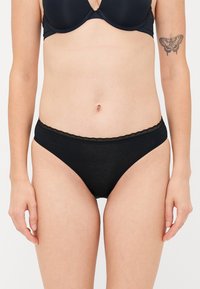 Mutande bikini in cotone nero con un delicato pizzo in vita, texture morbida e un classico taglio a vita bassa.