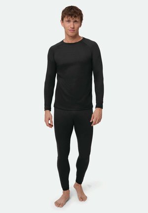 Top térmico negro de manga larga con cuello redondo y diseño ajustado; combinado con leggings largos negros ceñidos, ambos hechos de tela elástica.