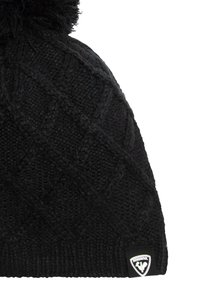 Gorro de punto negro con un patrón de diamante texturizado, que presenta un pompón esponjoso en la parte superior y una etiqueta negra de marca en el lateral.