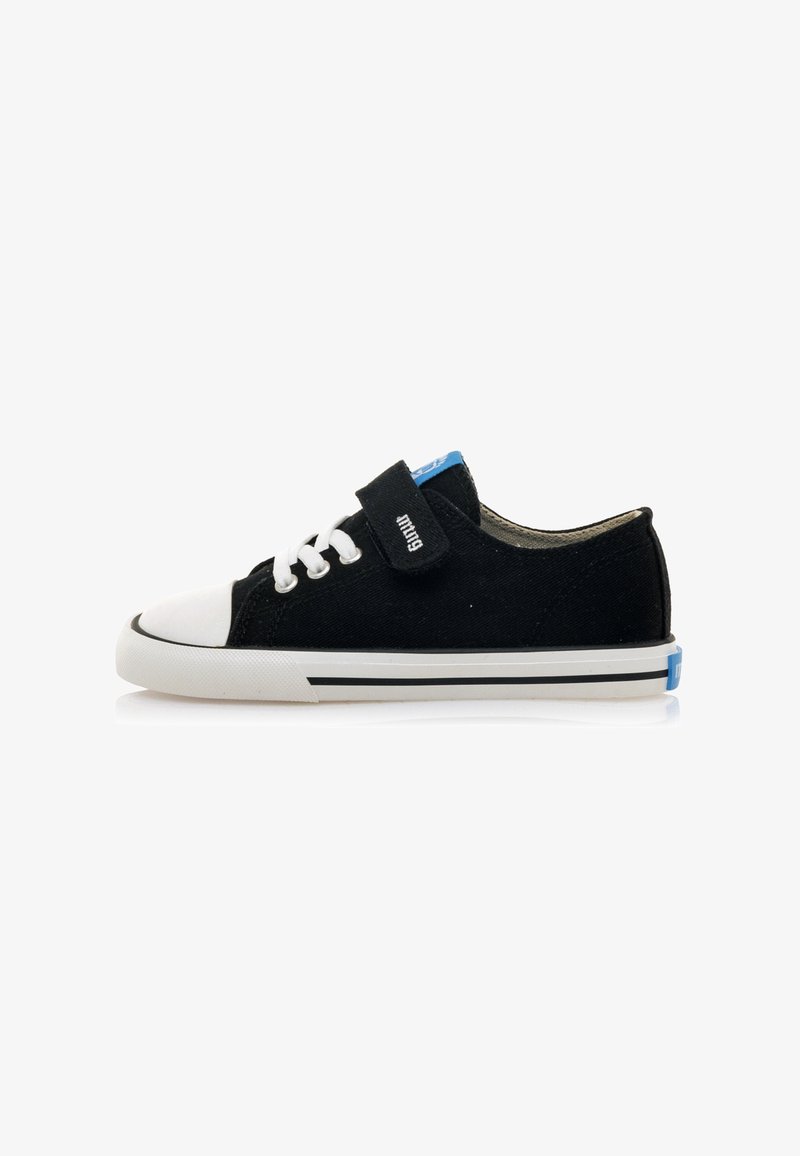 Zapatillas de lona negras con puntera de goma blanca, cordones blancos, una correa de Velcro y un acento azul en el talón con rayas en blanco y negro.