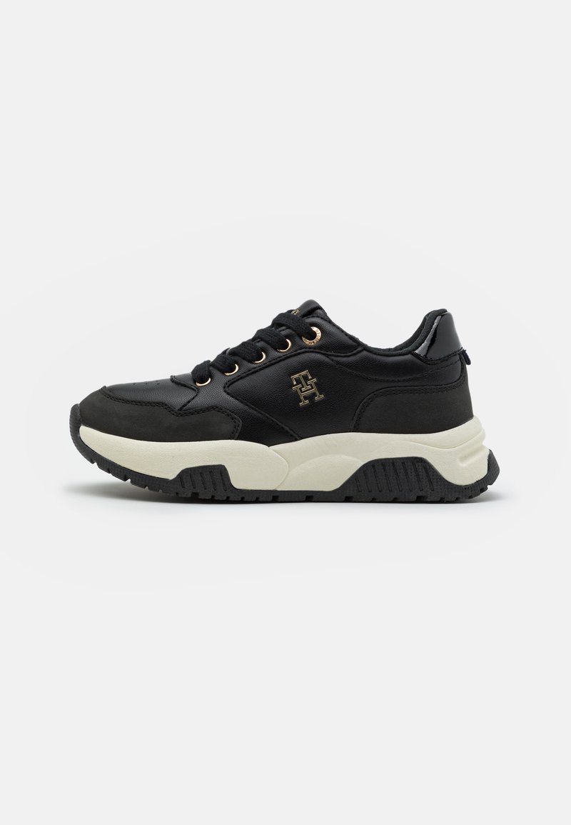 Zwarte sneaker met een textuurstof bovenwerk, gouden accenten, een chunky witte tussenzool en een zwarte rubberen outsole. Beschikt over ronde veters en logo-detail.