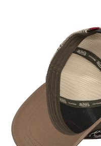 Gorra trucker marrón y beige con visera curva, respaldo de malla y acento rojo. Cuenta con etiquetas de marca internas y tejido texturizado.