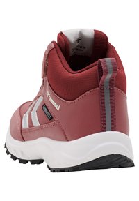 Rode waterdichte hoge schoen met een gestructureerde afwerking, reflecterende accenten en een witte zool. Beschikt over een klittenbandsluiting en een zwarte rubberen zool.