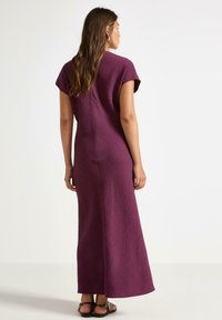 Lang, lilla, struktureret kjole med korte ærmer og lige snit, der har en midterste bagsøm og minimale designindtryk.