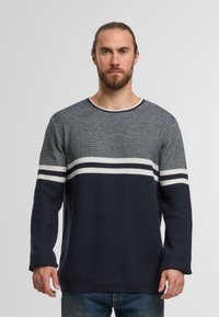 Dunkelblauer Pullover mit strukturiertem Strick. Verfügt über einen horizontalen weißen Streifen über der Brust. Rundhals und lange Ärmel.