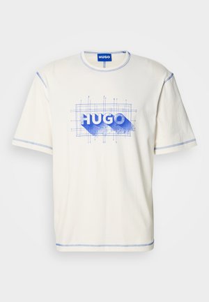 T-shirt di cotone color crema con cuciture blu, con stampa grafica della parola "HUGO" e dettagli in stile progetto tecnico sul davanti.