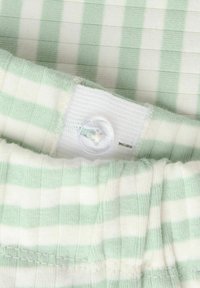 Lys grønn og hvit stripet stoff med en ribbet tekstur. Har en hvit elastisk linning med en klar plastknappdetalj.