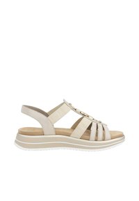 Beige Sandale mit offenem Zehenbereich, mehreren Stoffriemen, dekorativen Metallakzenten, gepolsterter Innensohle und einer weißen Gummisohle.