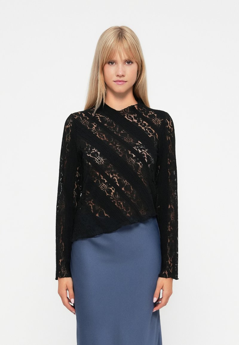 Schwarzes Spitze-Oberteil mit langen Ärmeln, diagonalem Muster, halbtransparenter Textur und hohem Kragen, kombiniert mit einem einfarbigen blauen Satinrock.