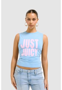 Top corto senza maniche di colore blu chiaro con la scritta "JUST JUICY" stampata in lettere rosa in grassetto. Materiale di cotone morbido. Abbinato a jeans blu chiaro.