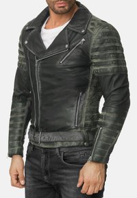 Giacca da motociclista in pelle nera e verde scuro con motivo trapuntato, zip asimmetrica e colletto con bottone automatico; vita con cintura. Tasche con zip.