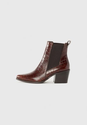 Botte de cheville en cuir brun à motif crocodile, avec des panneaux élastiques noirs sur les côtés et un talon bloc, présentant un bout arrondi et une languette.