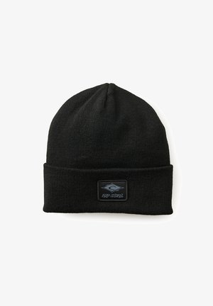 Gorro de punto negro con puño doblado y un parche rectangular de goma que presenta el texto "RIP CURL" y un diseño de ola.