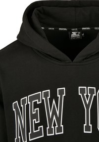 Sweat à capuche noir avec capuche et inscription "NEW YORK" en grandes lettres blanches délimitées sur la poitrine, étiquette de la marque Starter à l'intérieur du col.