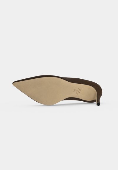 Brauner High-Heel-Schuh mit spitzer Spitze, von der Sohle gezeigt, liegt auf der Seite mit beigem Boden und dünnem Stiletto-Absatz.