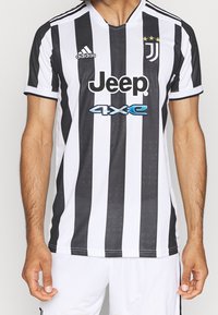 Maillot Adidas à rayures noires et blanches avec un col en V, trois étoiles au-dessus du logo, et le logo "Jeep" sur le devant.