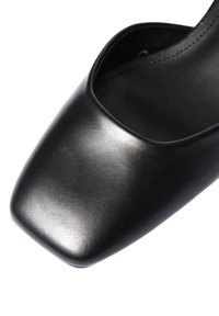 Scarpa con tacco alto in pelle nera, design a punta squadrata, texture liscia e lato aperto. Estetica minimalista e moderna.