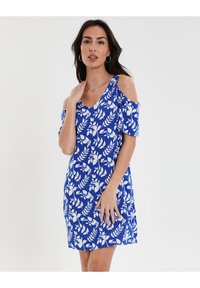 Vestido azul con estampados de flores y hojas blancas, diseño off-the-shoulder, mangas cortas y corte a la altura de la rodilla. Textura de tela suave.