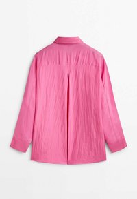 Blouse à manches longues rose vif avec col, pli dans le dos et larges poignets, vue de dos sur fond blanc.