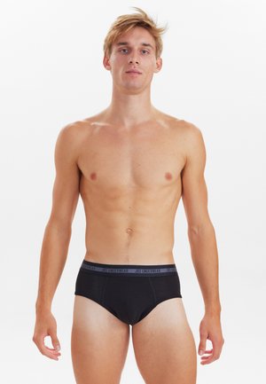 Sorte briefs med en grå elastisk talje, der har teksten "JBS UNDERWEAR." Lavet af glat stof, designet til en tætsiddende pasform.