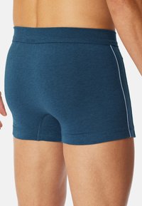 Herrens mörk teal boxershorts gjorda av mjukt, luftigt tyg, med en åtsittande passform, enhetlig färg och kontrasterande vita sidodetaljer.