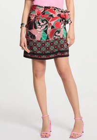 Kleurvolle bloemenprint rok met een zwarte basis, voorzien van een strik in de taille, een contrasterend geometrisch patroon aan de zoom en een aansluitend ontwerp.