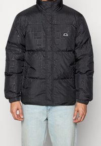Czarna kurtka puchowa z tonowanym wzorem z wypukłym tekstem, wysokim kołnierzem, zapięciem na zamek i elastycznymi mankietami. Posiada boczne kieszenie oraz detal z logo.