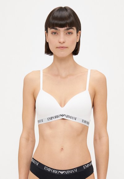 Soutien-gorge blanc avec des fines bretelles, design en V et bande élastique arborant le logo "Emporio Armani". Texture unie, sans rembourrage.