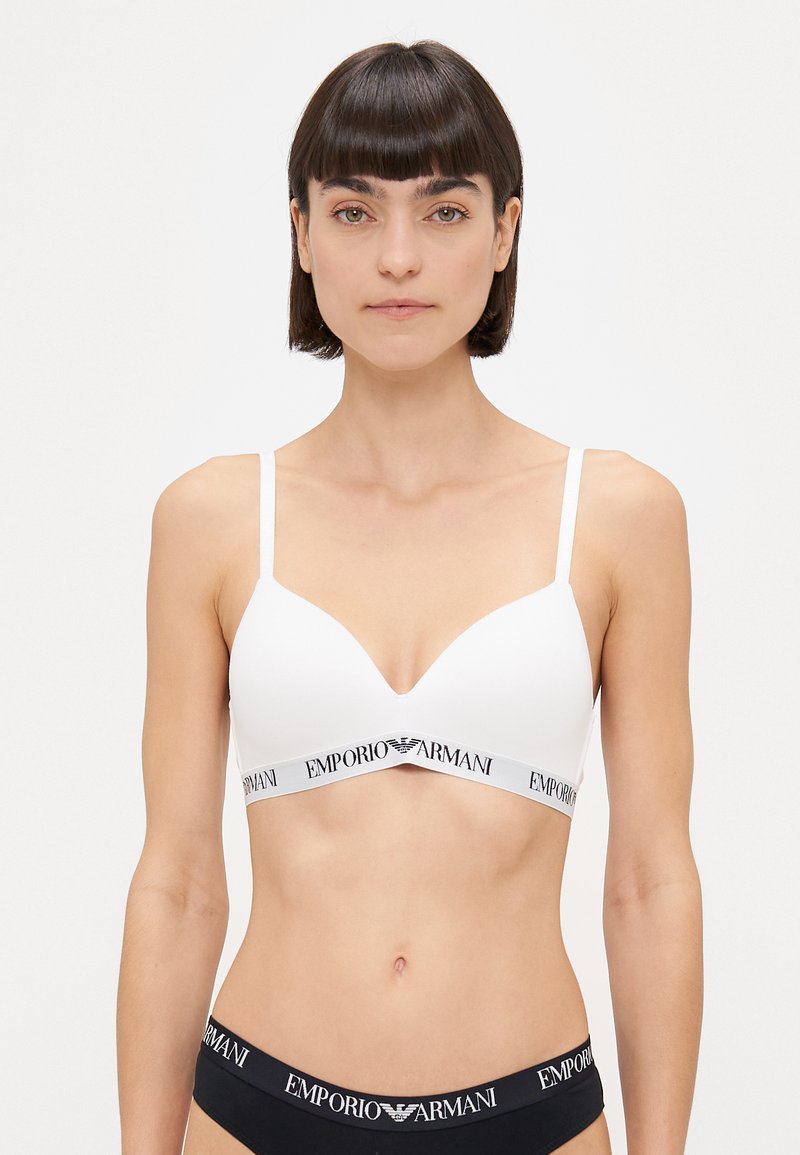 Sutien alb cu bretele subțiri, design cu decolteu în V și bandă elastică cu logo-ul "Emporio Armani". Textură simplă, fără întăriri.