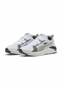 White athletic shoes with grey accents, mesh upper, flat laces, padded collar, and textured rubber sole. Features side stripes and branding.