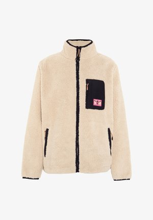 Fleece jacket in cream with black accents. Features a full zipper, high collar, one chest pocket, and two side pockets. Soft texture.