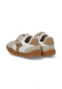 Zapatos para toddler en blanco y beige con una correa de velcro, hechos de cuero y textil, con una suela de goma redonda y detalles de costura.