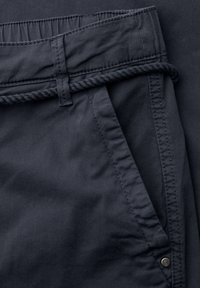 Pantalon gris foncé avec poche latérale et ceinture en corde torsadée passée dans les passants de ceinture.