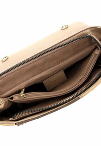 Beige leren handtas interieur met meerdere compartimenten; bevat een ritssluiting en een gladde stoffen voering met een subtiele textuur.