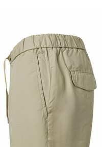 Pantaloni beige a vita elastica con tasca laterale e texture liscia, caratterizzati da dettagli di cucitura discreti e un design dal taglio rilassato.