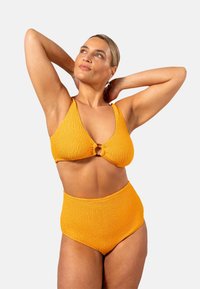 Gul strukturerad bikini-set med en triangulär topp med en rund detalj och högmidjade bottnar. Slät tyg, minimal detaljering.