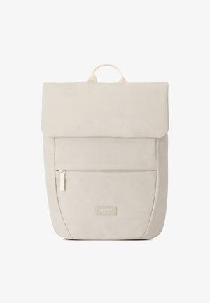Mochila color blanco roto con tapa plegable, bolsillo con cremallera en la parte frontal, textura suave y un asa superior; presenta una etiqueta de marca en la parte delantera.