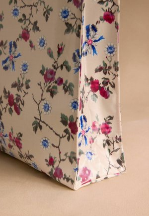 Gėlių pintinė, pagaminta iš tvirto audinio, su kreminiu fono atspalviu ir mėlynomis bei rožinėmis gėlių raštais, bei žaliais lapais. Plokščias pagrindas stabilumui.