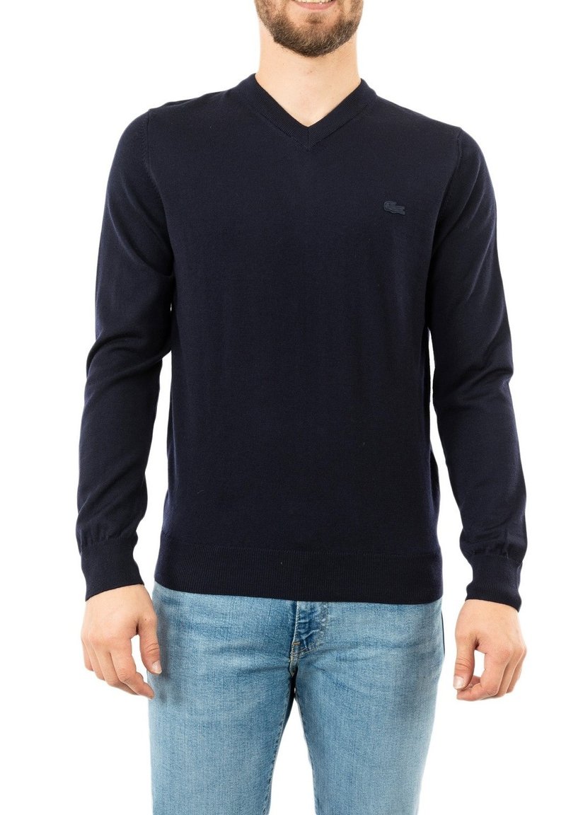 Pullover V-neck blu navy realizzato in tessuto morbido, con maniche lunghe e orlo a costine. Dettaglio logo discreto sul petto.