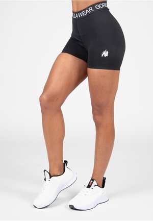 Black athletic shorts featuring a Gorilla Wear waistband and logo, crafted from stretchy material, paired with white athletic shoes.