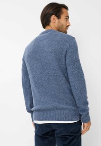 Maglione lavorato a maglia blu con finitura texturizzata, dotato di scollatura a girocollo e polsini e orlo a coste. Mostra la vista posteriore con spalle senza cuciture.