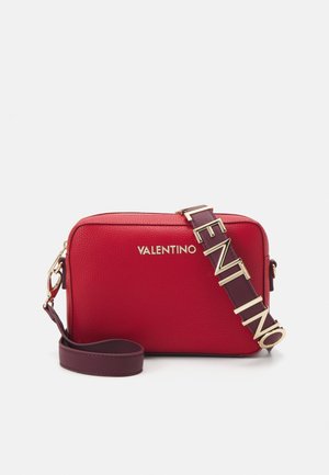 Sac bandoulière Valentino rectangulaire en cuir rouge avec une large sangle bordeaux portant le mot "Valentino" en lettres dorées.