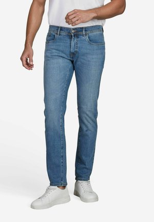 Blue denim jeans with a slim fit, featuring five pockets, a button fly, and subtle stitching. Worn with white sneakers.